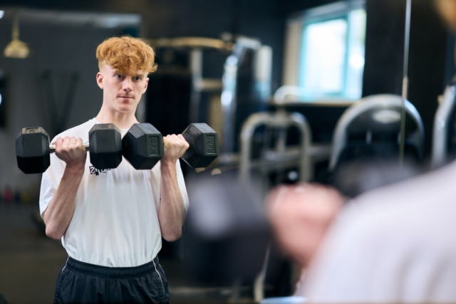 Student doing weights in the Athletic Suite