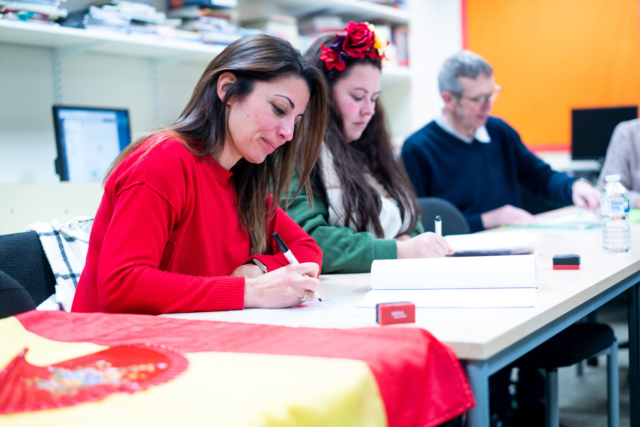 Some students write on whiteboards Beginners Spanish